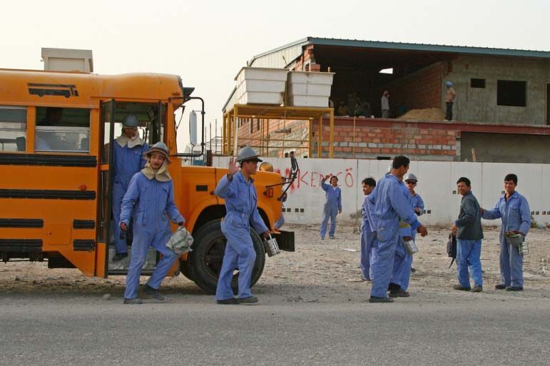 Workers in Qatar exit bus.