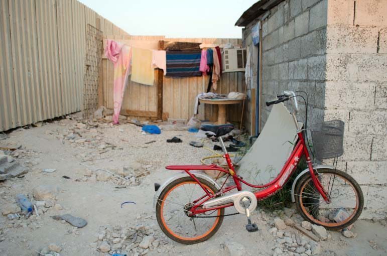 A bike stands before drying laundry in a labor camp in Qatar’s As Sayliyah district.